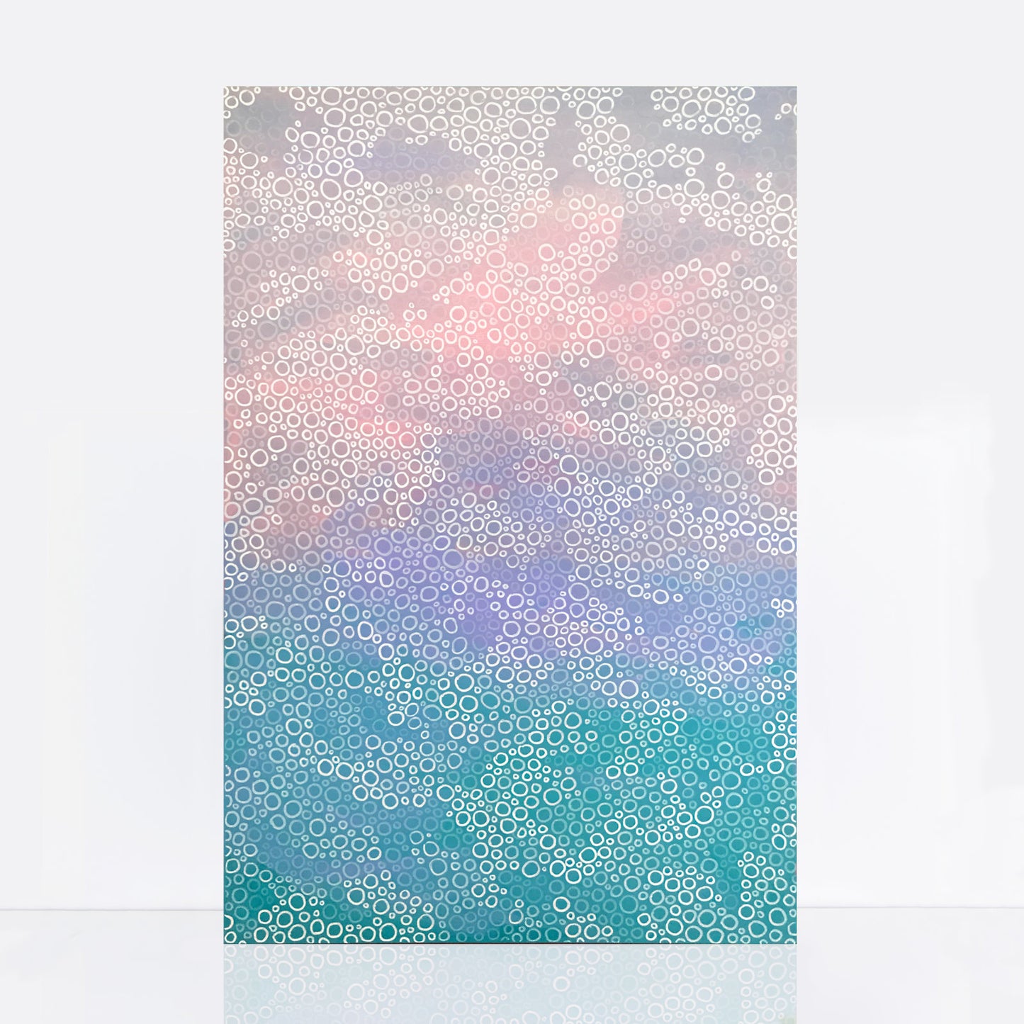 A painting titled "Coral Seas" features a gradient of soft hues transitioning from cool blues and greens at the bottom to warm pinks and greys at the top. The artwork is filled with intricate, repetitive circular patterns reminiscent of coral polyps, creating a textured and harmonious underwater landscape.