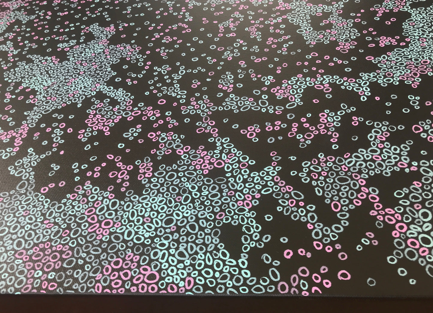 Detail of an abstract painting with soft pink and pale blue shapes scattered across a black background, inspired by visual snow and neural patterns.