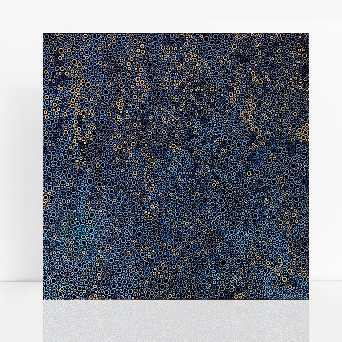 abstract painting in a mix of beautiful blue shades with cream detail is comprised of hundreds of circles of various sizes