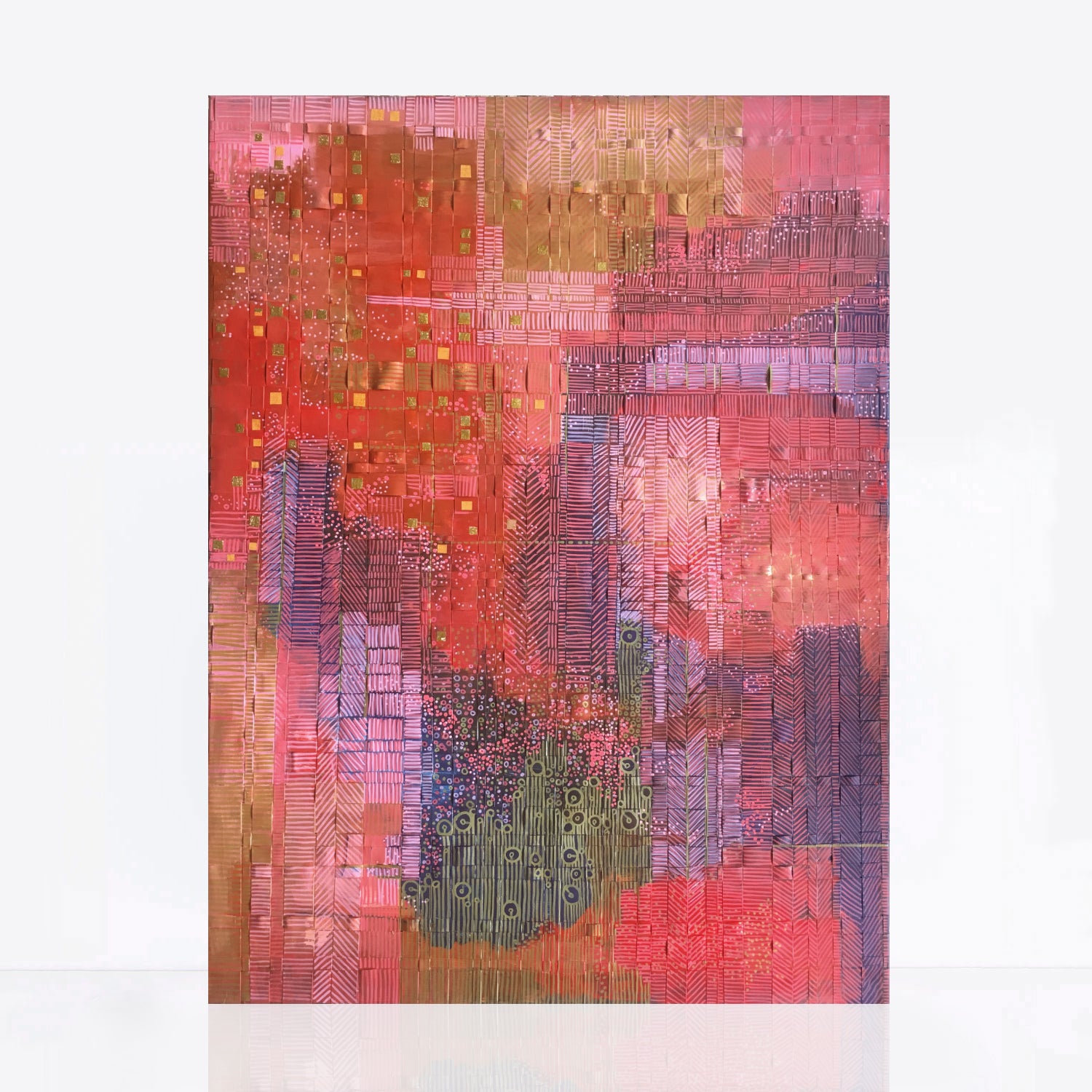 "Unearthed" is an abstract mixed media painting featuring vibrant shades of red and blue with intricate patterns in red, pink, and gold. The artwork is created using woven strips of recycled paper wrapped around a lightweight canvas and painted with acrylics, with additional pieces of gold paper for texture. The patterns and marks symbolize the environmental impact of mining in the West Australian desert, yet appear paradoxically beautiful from an aerial perspective.