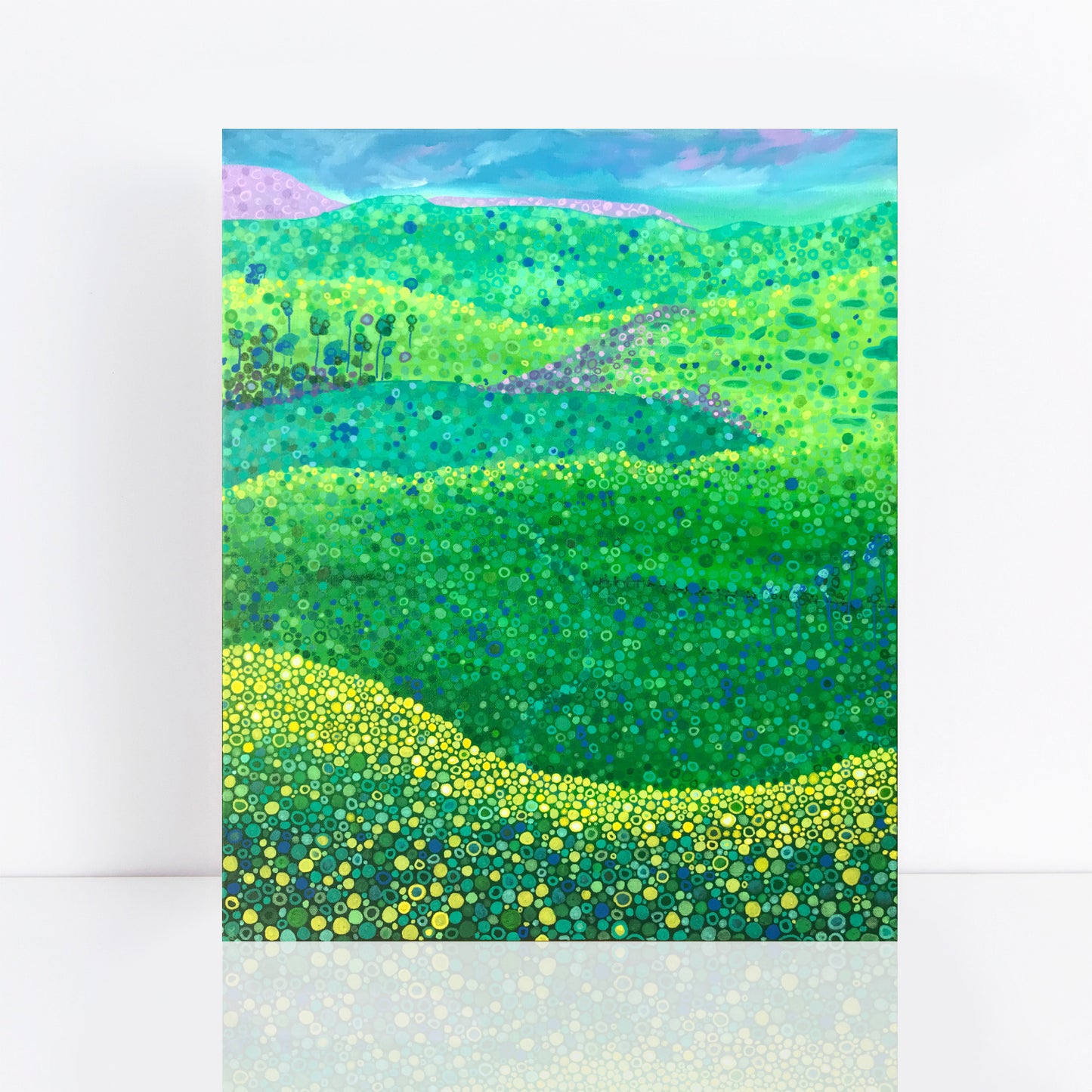 colourful pointillist painting of fields on canola