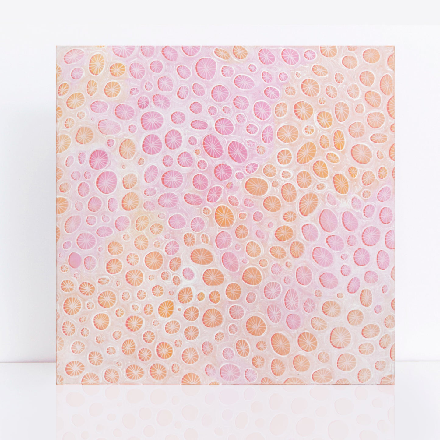 square abstract painting in a mix of pinks and peach with coral design