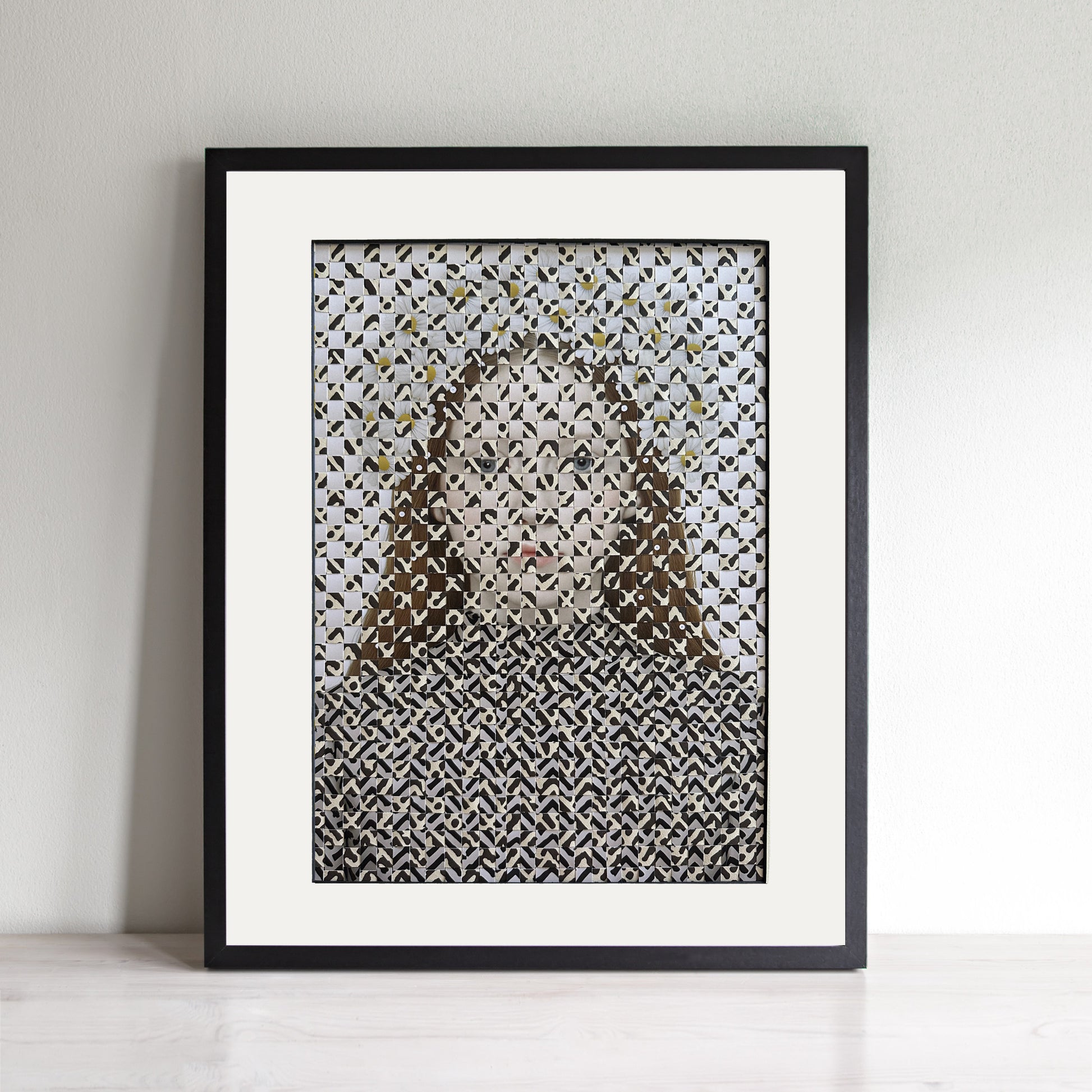 Framed abstract woven art with geometric pattern on a white wall