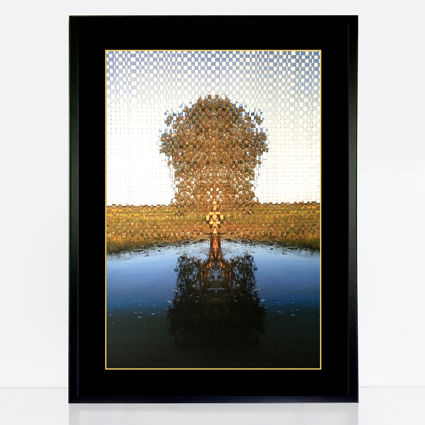 solitary gum tree stands on the bank of a river. The top half of the image has been woven with post consumer recycled paper with bits of gold and sparkling green paint running through the pattern