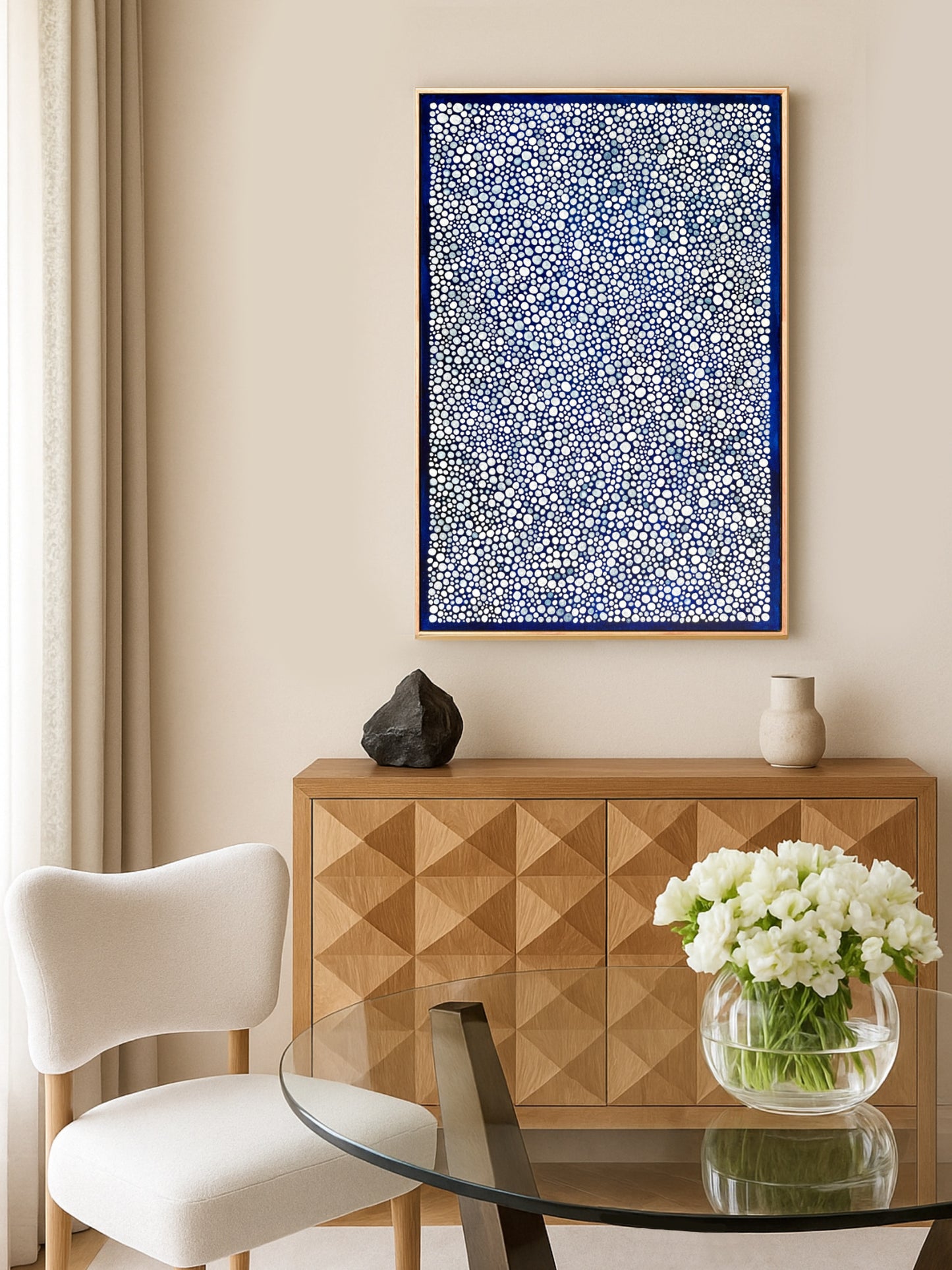 Modern interior with a wooden sideboard, white chair, and abstract blue artwork.
