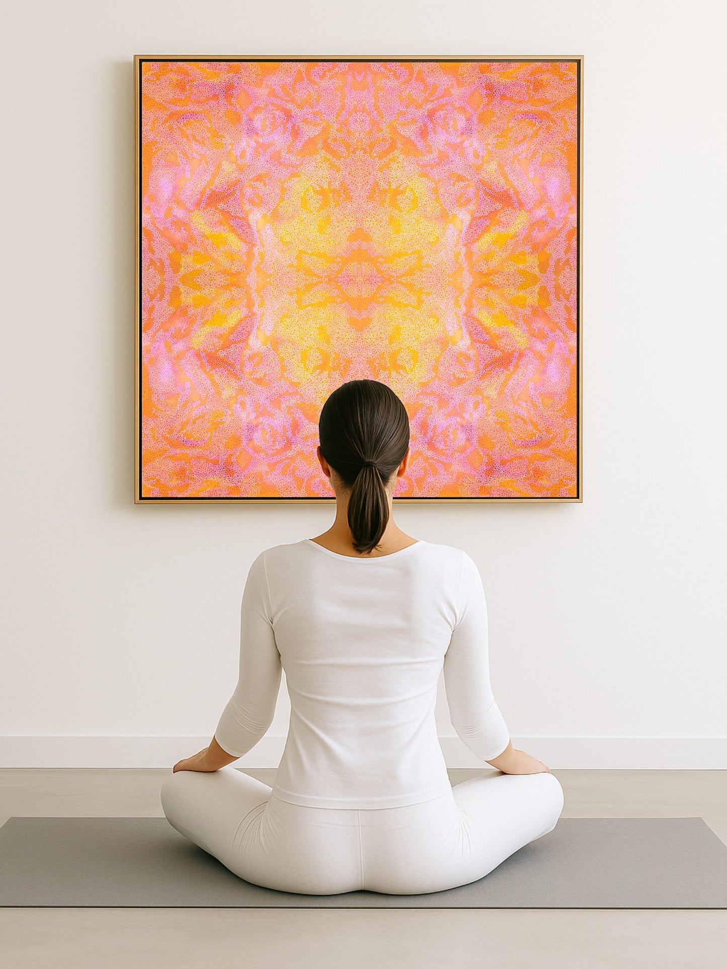 Person sitting in a meditative pose on a yoga mat in front of a colorful abstract painting.
