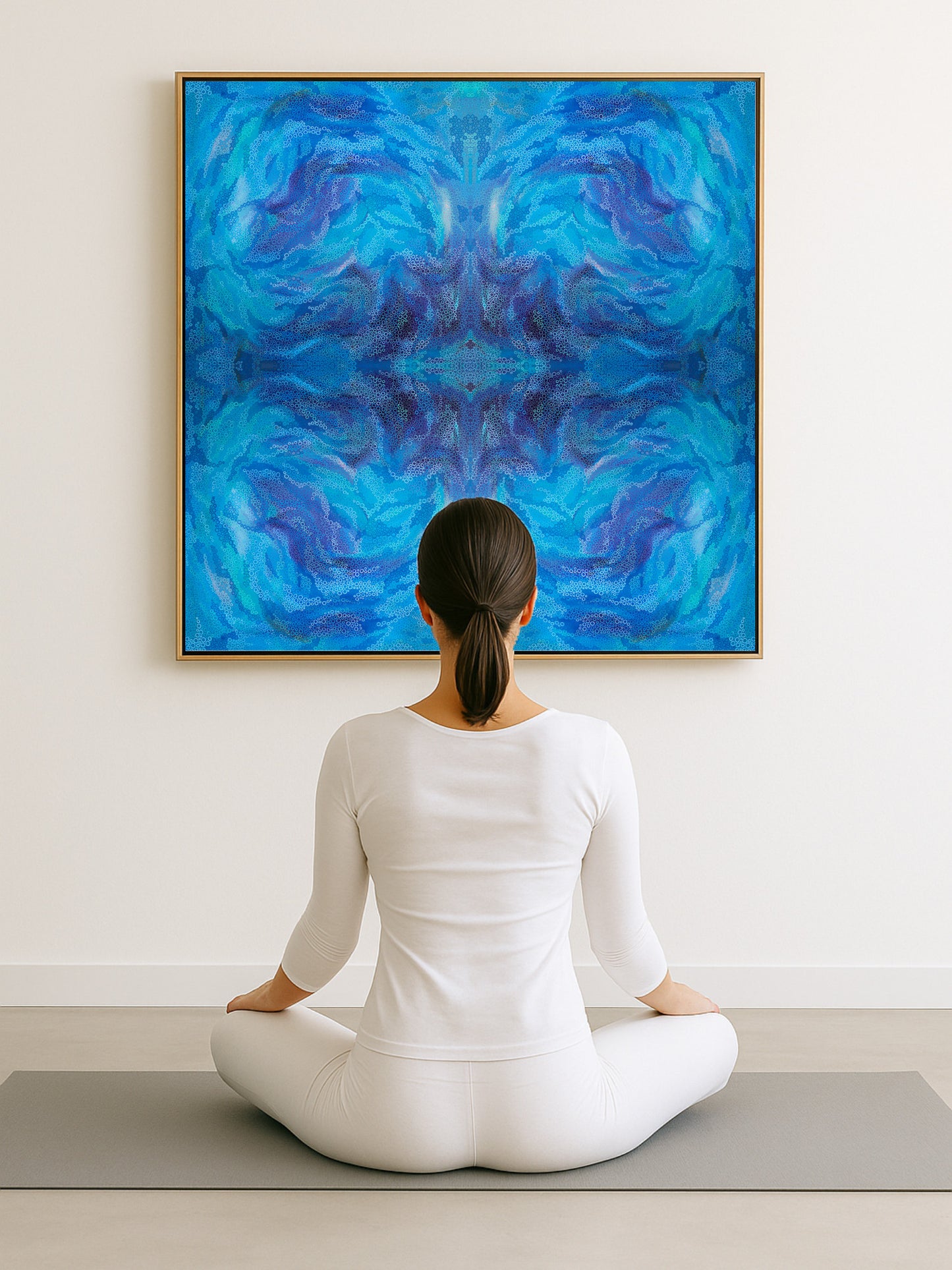 Person sitting in meditation pose in front of a large blue abstract painting.