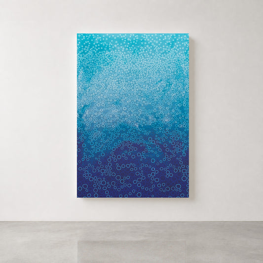 A vertical canvas wall art print featuring a blue gradient pattern with white and blue circles, displayed on a light gray wall above a concrete floor.